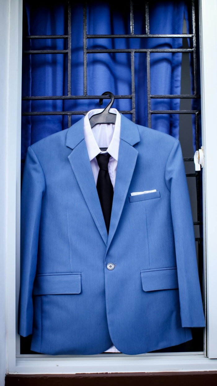 Elegant blue suit hanging on window bars