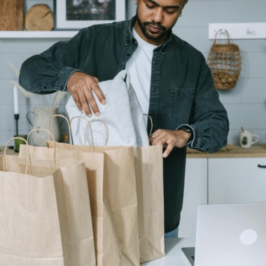 Man in Black Suit Jacket Holding White Paper Bag