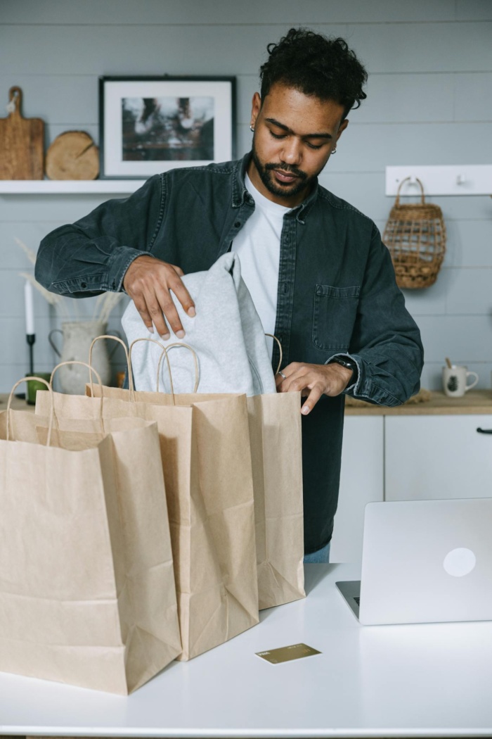 Man in Black Suit Jacket Holding White Paper Bag